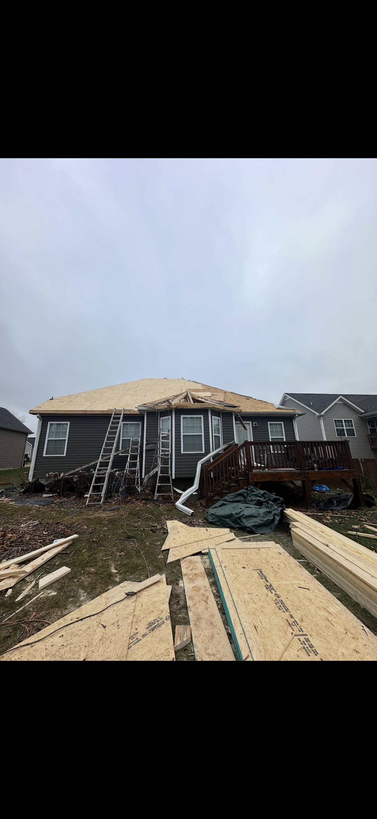 Roof decking exposed during tear-off on gray home