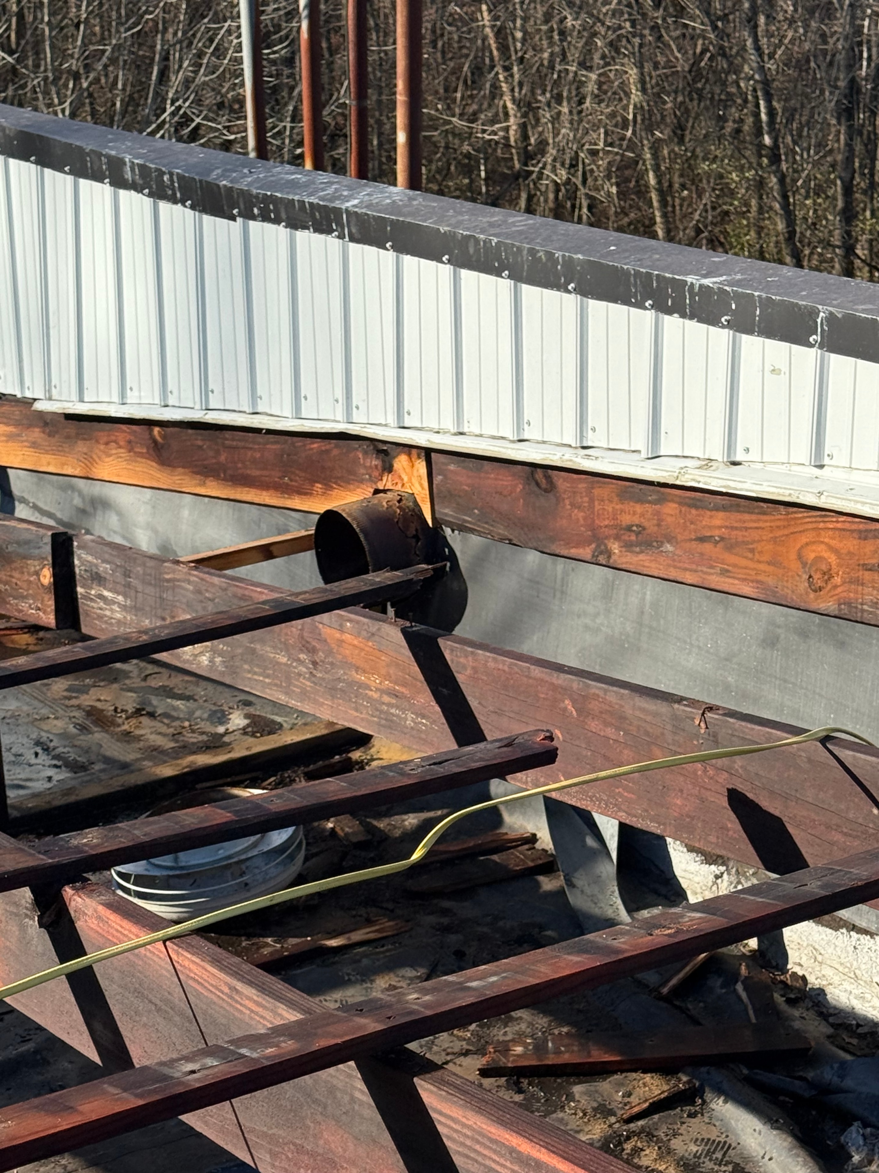 Close-up of metal roofing and damaged decking during commercial repair